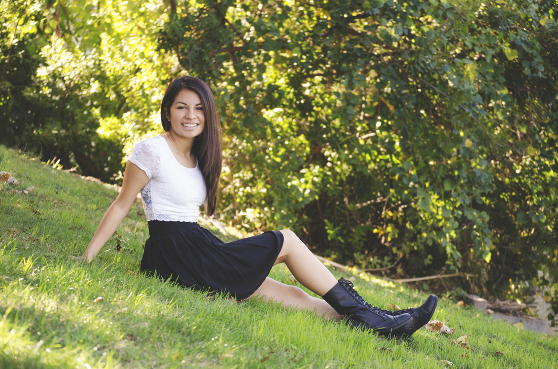 Image of girl in black dress sitting on lawn | Celebrity Ortho Dentist