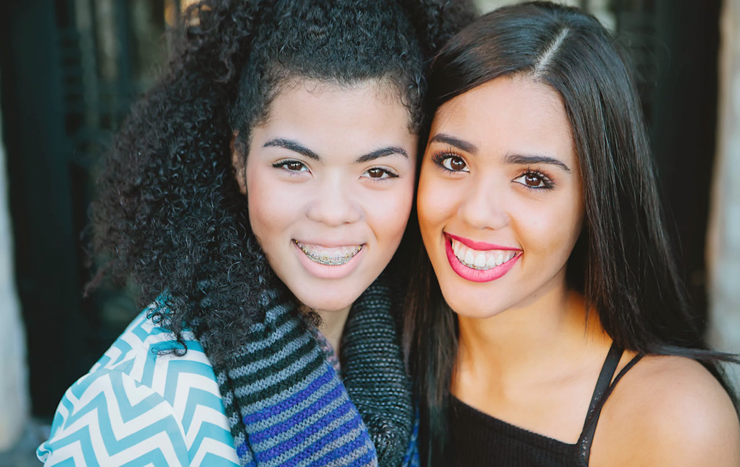 Girl with braces posing with girl with Invisalign® for photo | Celebrity Orthodontics