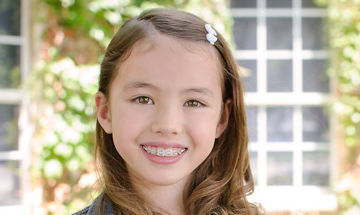 Young girl with braces smiling for photo | Celebrity Orthodontics