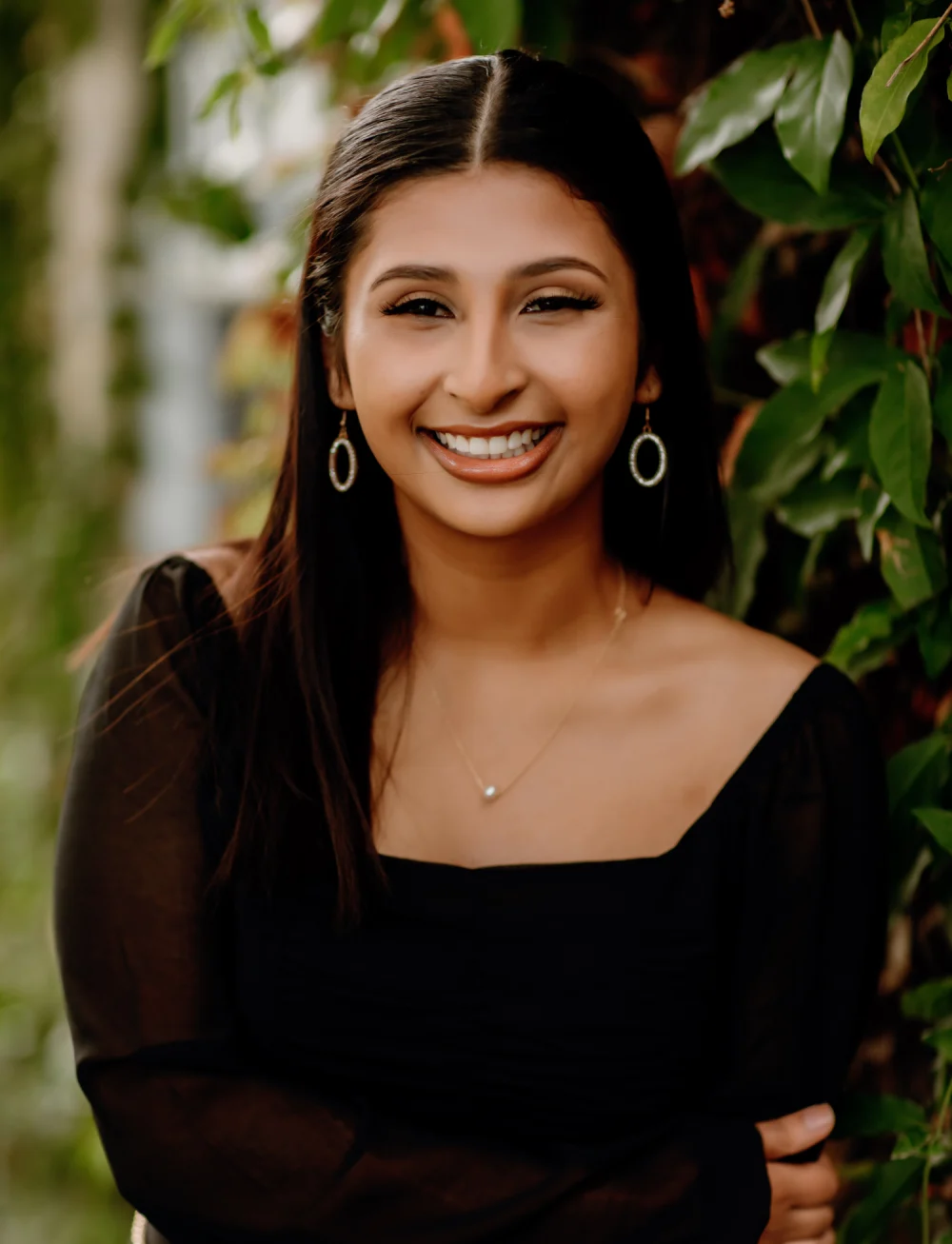 Smiling dark-haired woman posing for photo | Celebrity Orthodontics