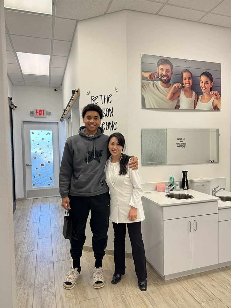 Dr. Thuy Do-deLatour posing with a pro-soccer player | Celebrity Orthodontics